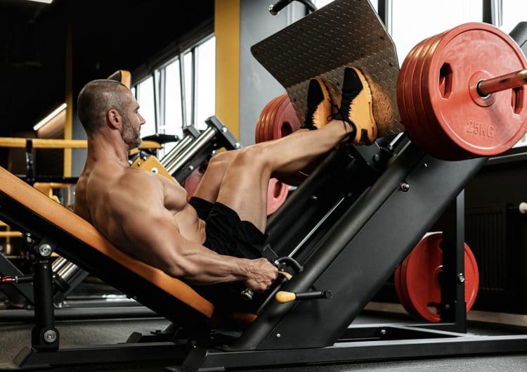 Bodybuilder Doing A Seated Leg Press Exercise
